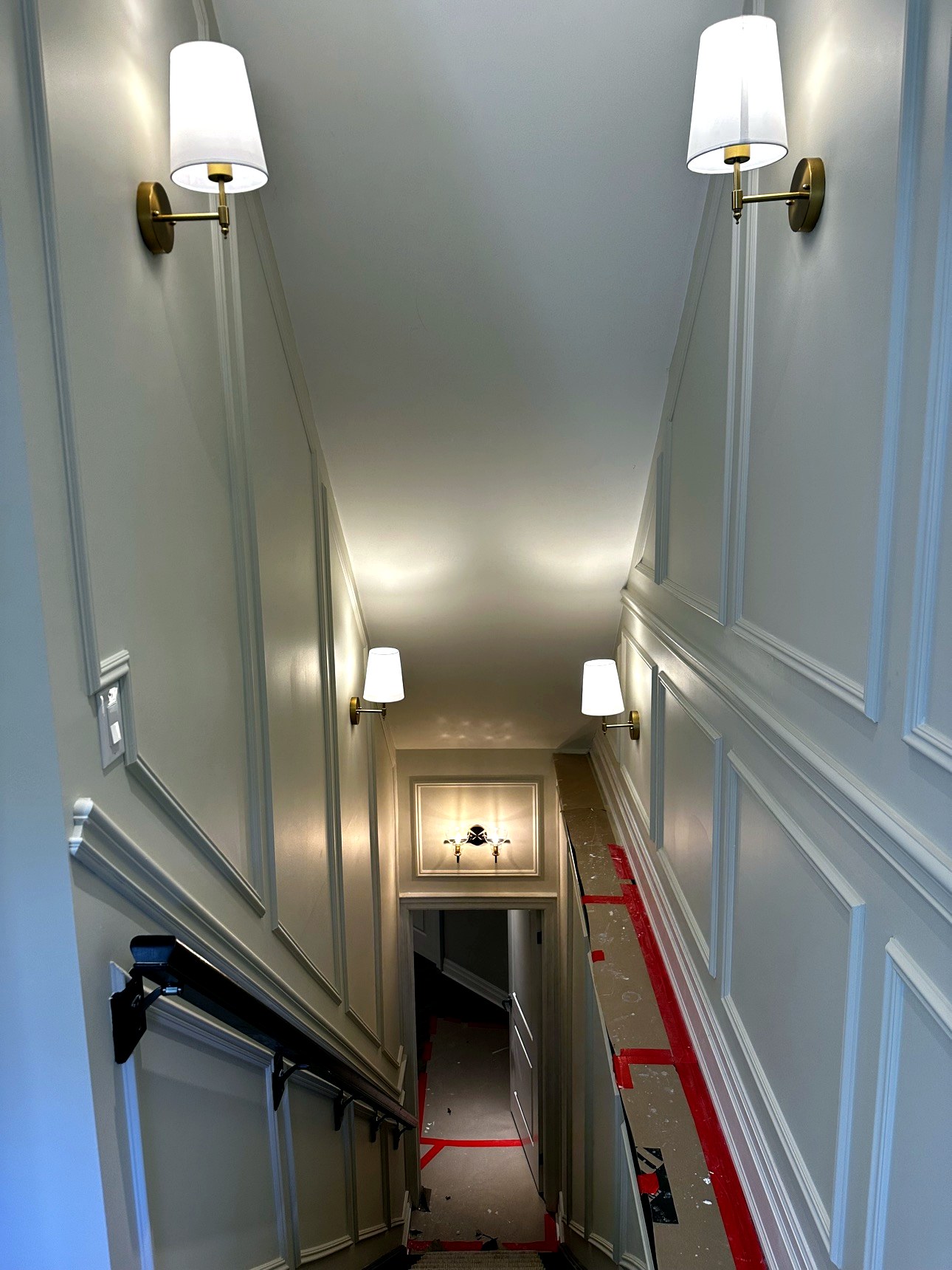 Brass sconce lighting on panelled accent wall